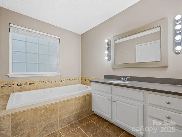 a bathroom with bathtub and window