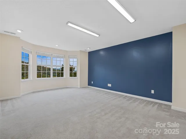 a view of an empty room with a flat screen tv and a window
