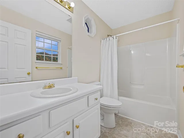a bathroom with a bath tub sink mirror vanity and toilet