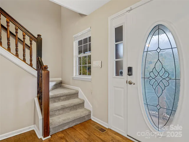a view of staircase with wooden floor and door