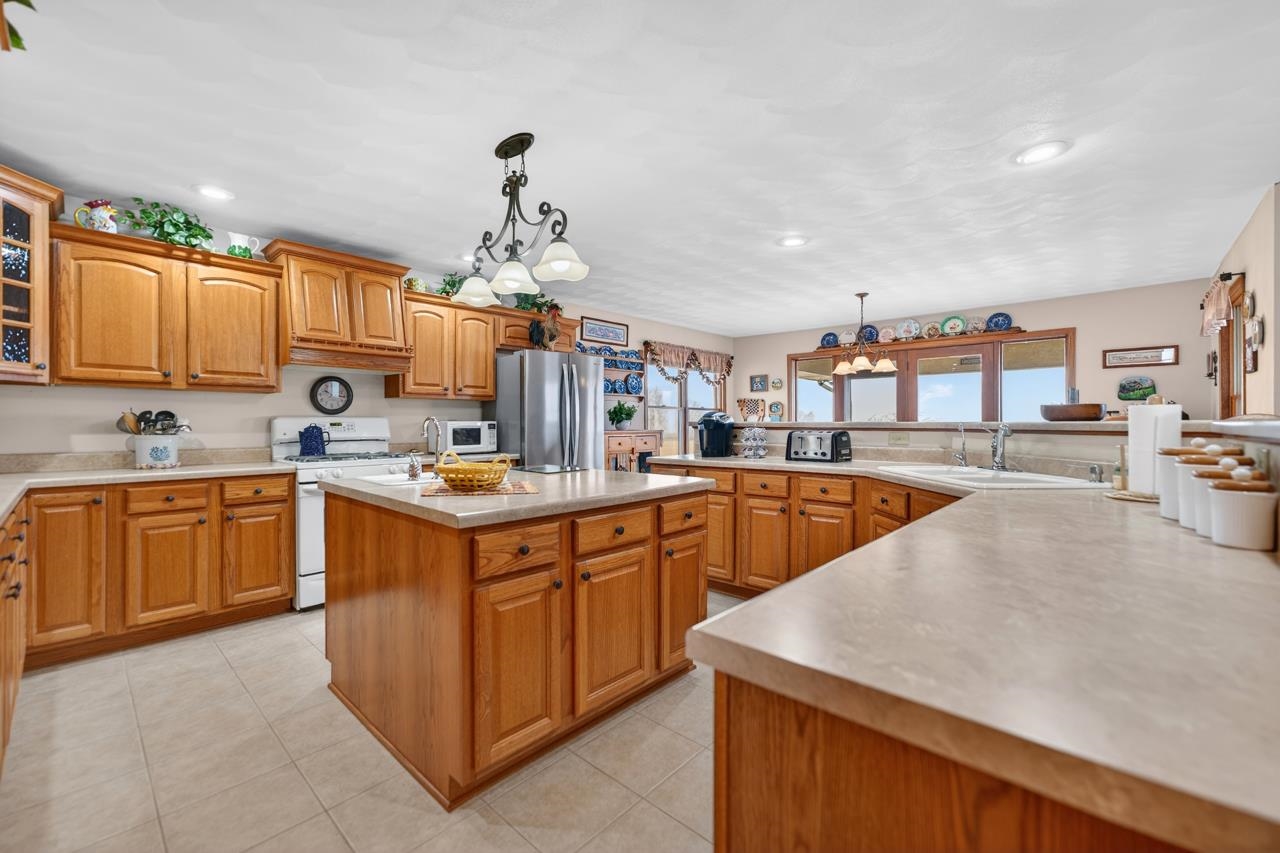 a kitchen with stainless steel appliances granite countertop a sink dishwasher stove and refrigerator with wooden floor