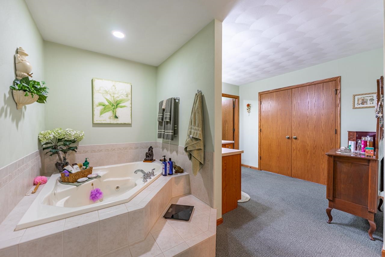 10023 Auburn Road Winnebago, IL 61088 - Photo 12 of 59 a bathroom with a tub sink and a mirror