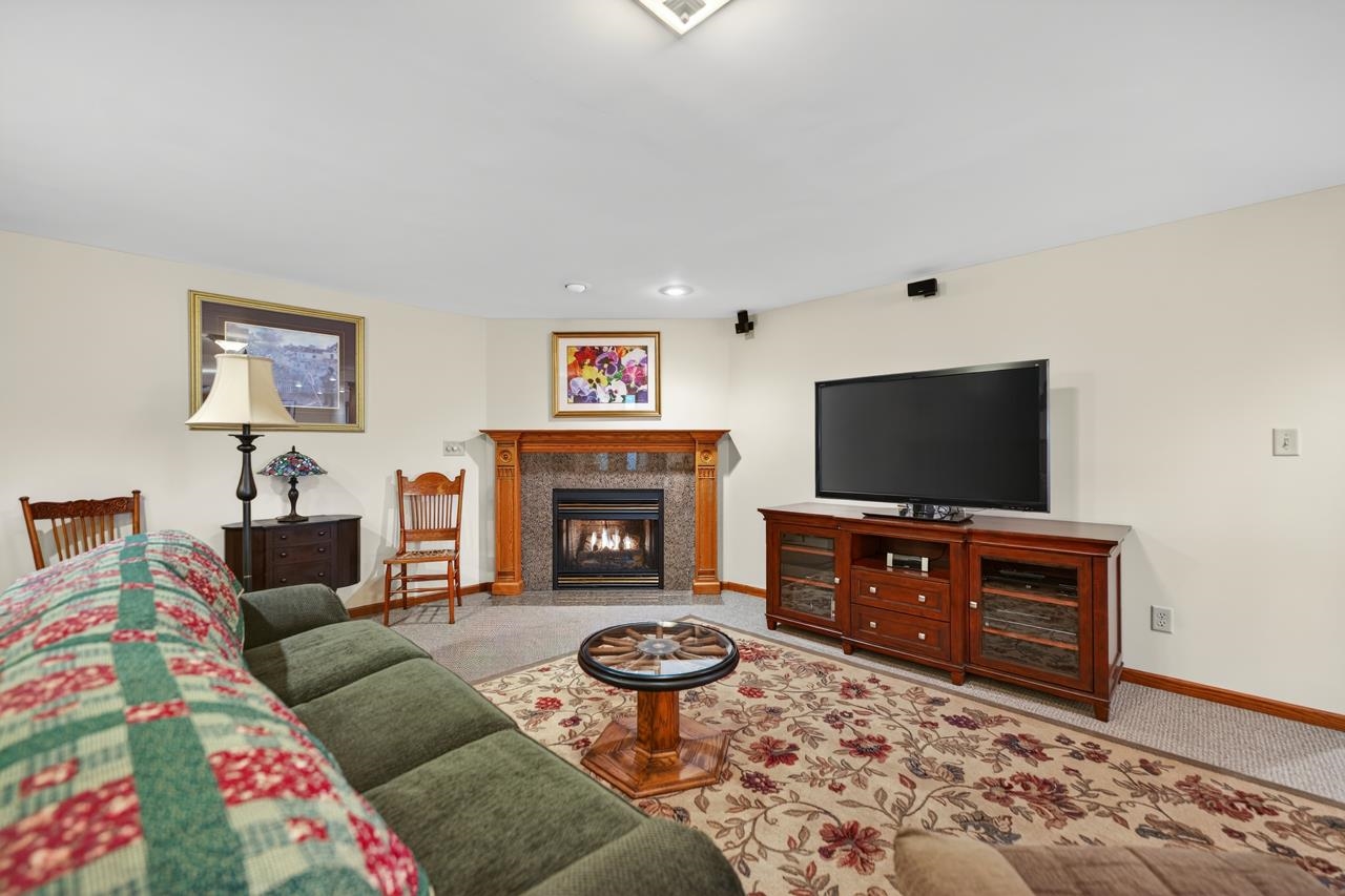 10023 Auburn Road Winnebago, IL 61088 - Photo 17 of 59 a living room with furniture a flat screen tv and a fireplace