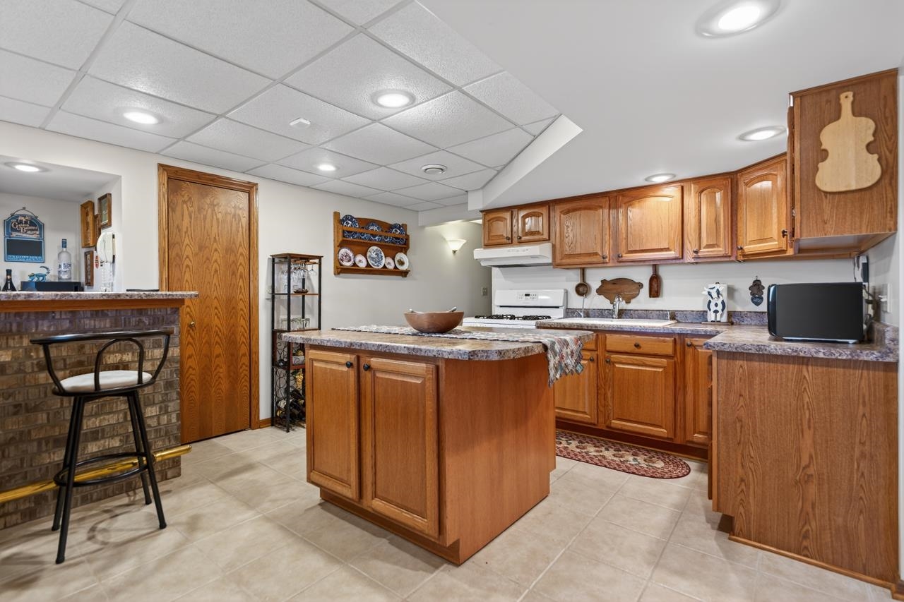 10023 Auburn Road Winnebago, IL 61088 - Photo 24 of 59 a kitchen with stainless steel appliances granite countertop a stove a sink dishwasher and a refrigerator