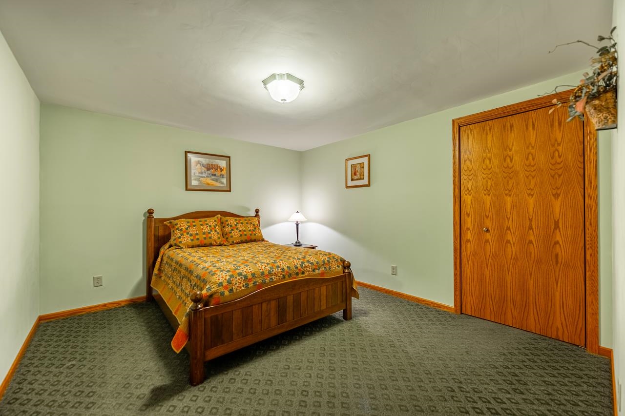 10023 Auburn Road Winnebago, IL 61088 - Photo 27 of 59 a bedroom with a bed and wooden floor