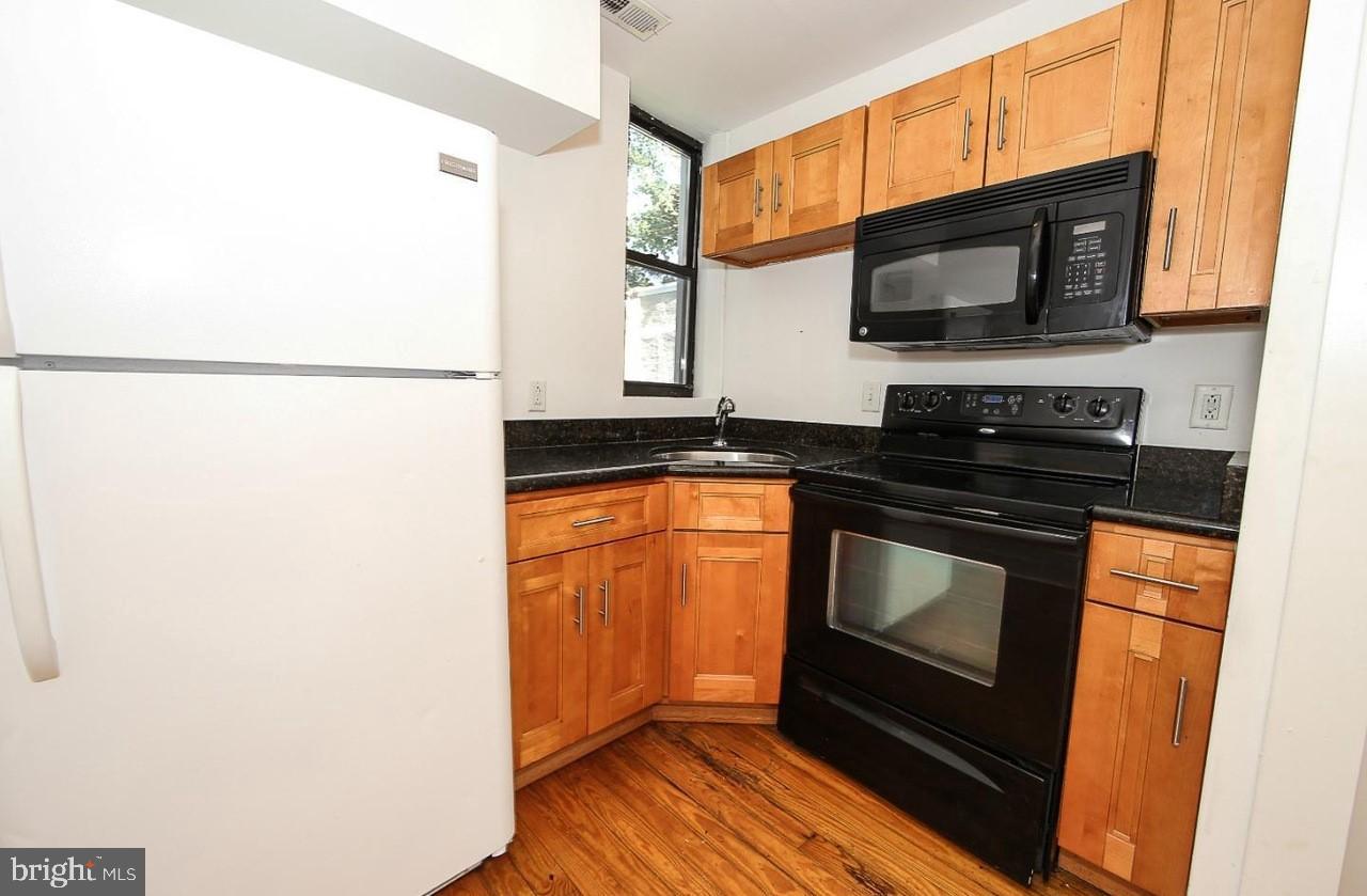 2018 North 18th Street, Unit B Philadelphia, PA 19121 - Photo 6 of 16 a kitchen with stainless steel appliances a stove a microwave and a sink
