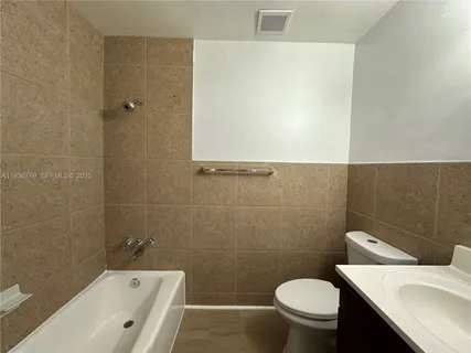 a white toilet sitting next to a bathroom sink