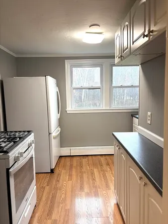 a kitchen with a wooden floor and a stove top oven