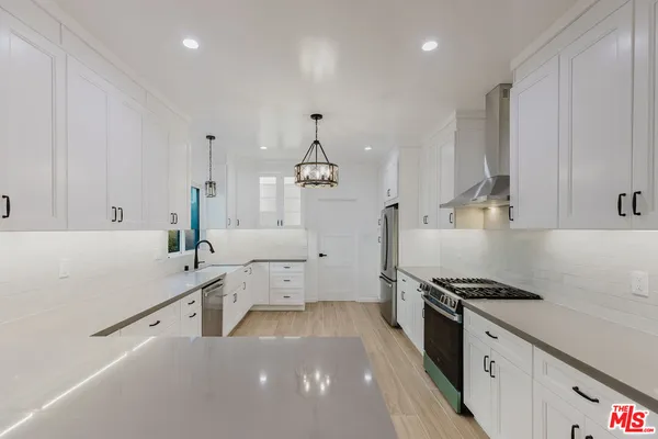 a kitchen with a sink appliances and cabinets