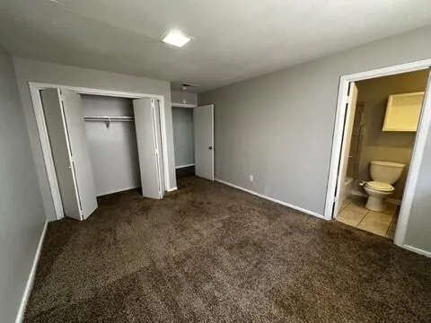 a bathroom with a granite countertop toilet sink and mirror