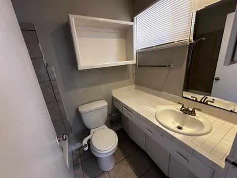 2003 32nd Street, Unit A Lubbock, TX 79411 - Photo 17 of 22 a bathroom with a granite countertop toilet sink and mirror