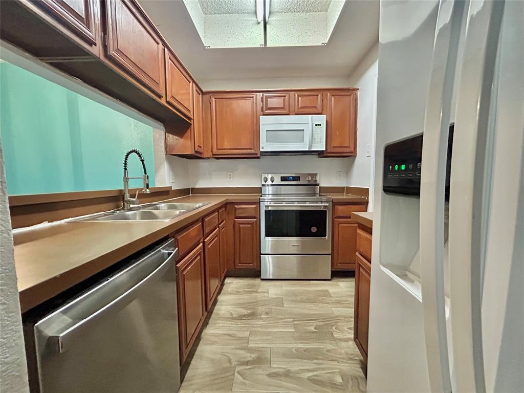 3609 West Northgate Drive, Unit 116 Irving, TX 75062 - Photo 3 of 8 a kitchen with stainless steel appliances granite countertop a stove a sink and a microwave