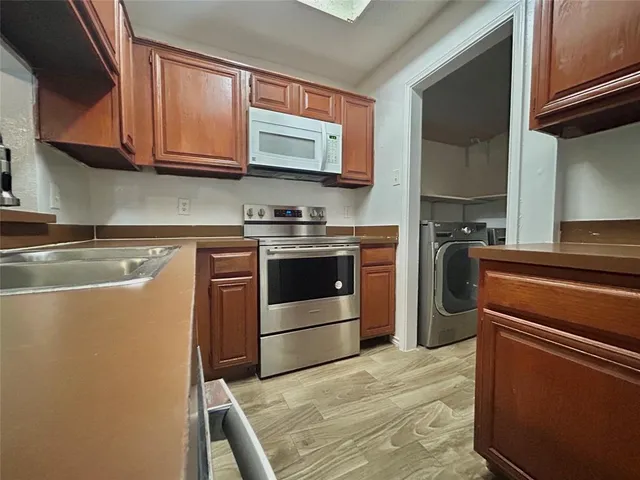a kitchen with stainless steel appliances granite countertop a stove a sink and a microwave