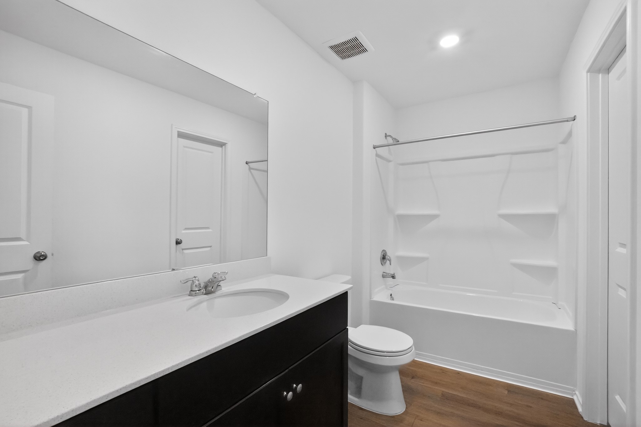 604 Marty Allen Loop Jarrell, TX 76537 - Photo 12 of 15 A well-lit bathroom features a modern vanity with a wide mirror and a pristine shower-tub combination.