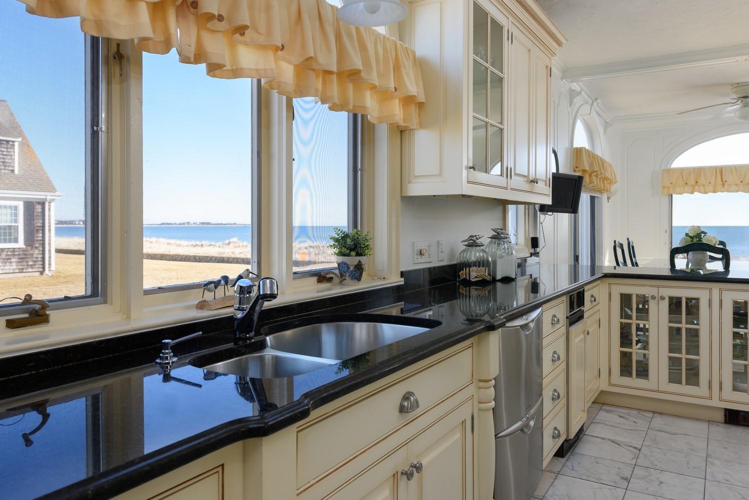 283 Long Beach Road Centerville, MA 02632 - Photo 18 of 30 a kitchen with stainless steel appliances a sink a counter and a window