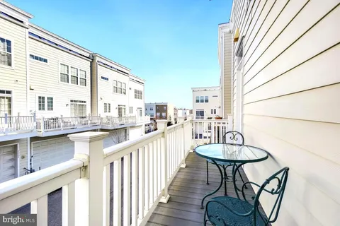 a view of a balcony with chairs and wooden fence