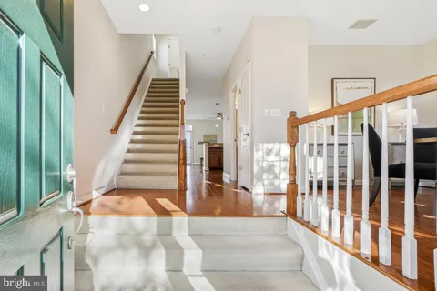 a view of staircase with lots of frames on wall and a large window