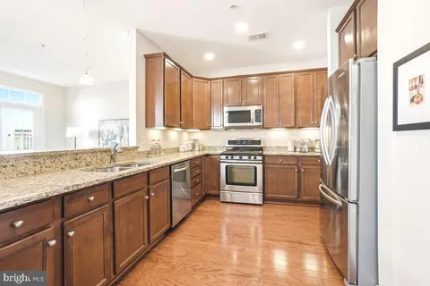 a kitchen with stainless steel appliances a refrigerator sink and cabinets