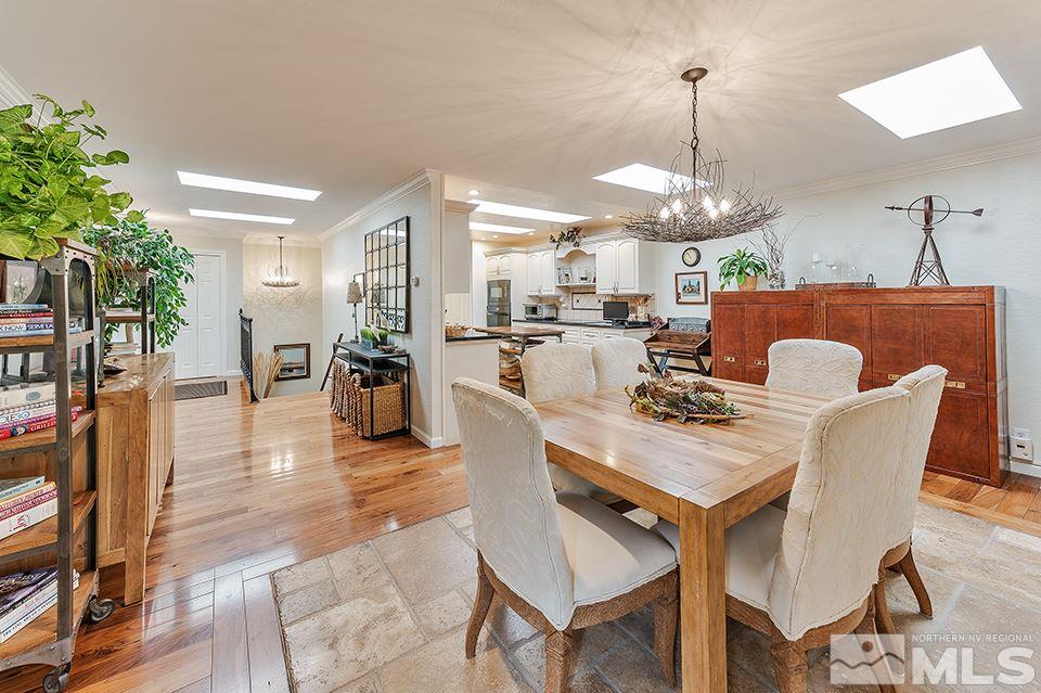 4945 West Lakeridge Terrace Reno, NV 89509 - Photo 6 of 25 a dining room with wooden floor a chandelier a wooden table and chairs