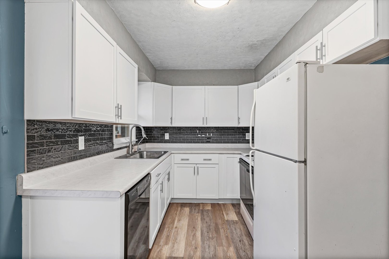 215 North 3rd Street Fisher, IL 61843 - Photo 11 of 32 a kitchen with a sink a stove a refrigerator and white cabinets