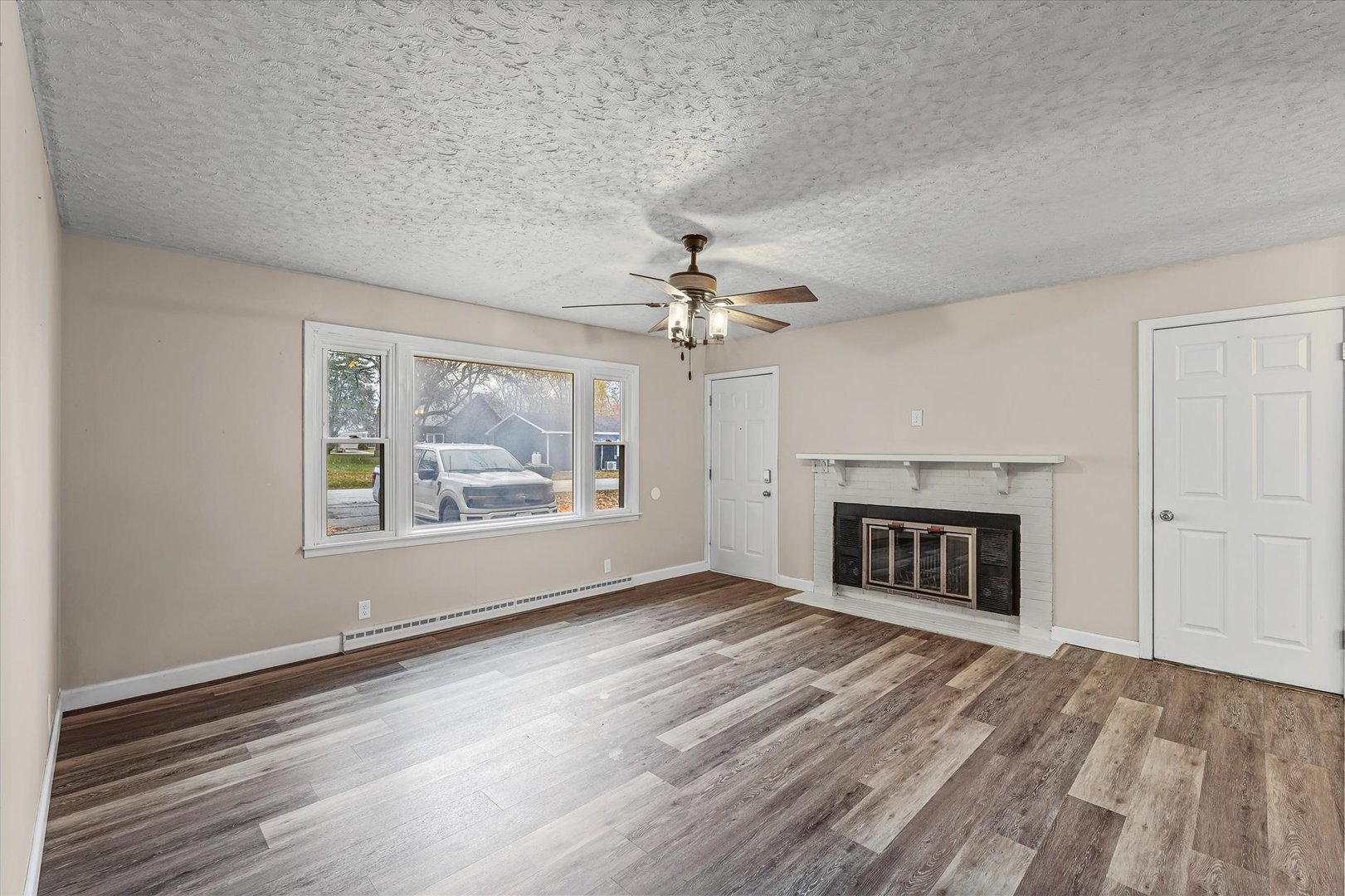 215 North 3rd Street Fisher, IL 61843 - Photo 6 of 32 an empty room with windows and fireplace