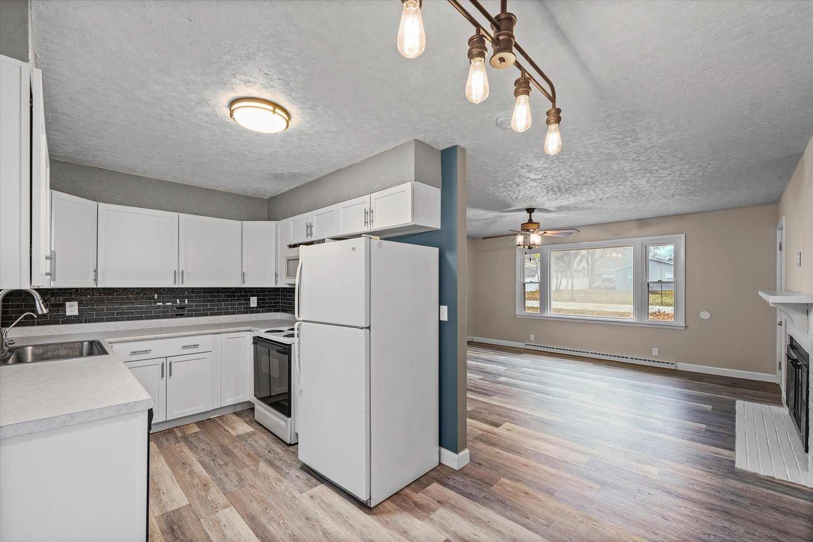 215 North 3rd Street Fisher, IL 61843 - Photo 10 of 32 a kitchen with a refrigerator a sink and dishwasher with wooden floor