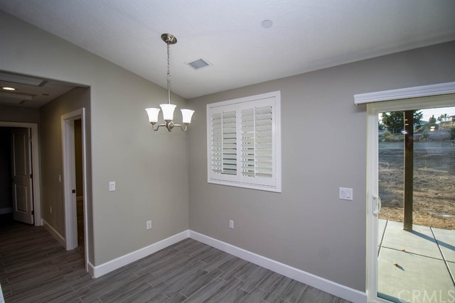 15648 Halinor Street Hesperia, CA 92345 - Photo 12 of 24 a view of an empty room with wooden floor and a window