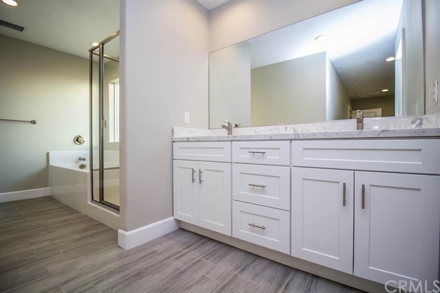 15648 Halinor Street Hesperia, CA 92345 - Photo 15 of 24 a spacious bathroom with a granite countertop sink and a mirror