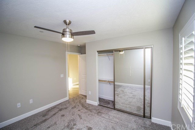 15648 Halinor Street Hesperia, CA 92345 - Photo 17 of 24 an empty room with windows and chandelier fan