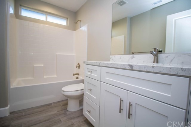 15648 Halinor Street Hesperia, CA 92345 - Photo 18 of 24 a bathroom with a granite countertop toilet sink and mirror
