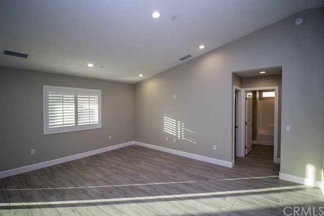 15648 Halinor Street Hesperia, CA 92345 - Photo 7 of 24 a view of an empty room with wooden floor and a window