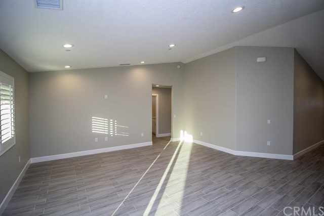15648 Halinor Street Hesperia, CA 92345 - Photo 8 of 24 a view of an empty room with wooden floor and a window
