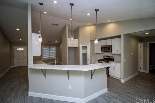 15648 Halinor Street Hesperia, CA 92345 - Photo 10 of 24 a large kitchen with stainless steel appliances kitchen island a large island in the center
