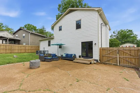 a view of a backyard with plants and large tree