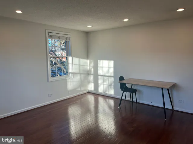 a view of a work space with wooden floor and a window