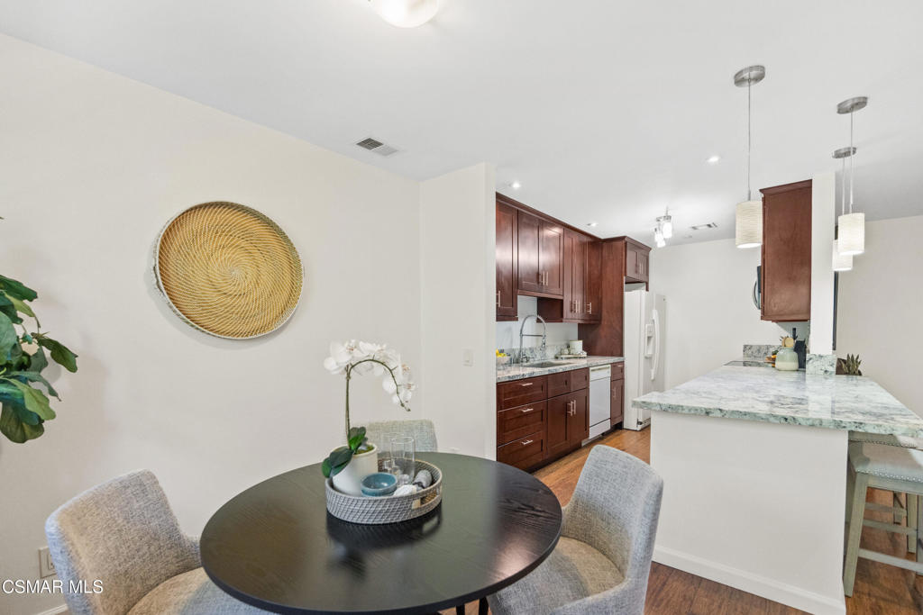 23637 Park Capri, Unit 36 Calabasas, CA 91302 - Photo 17 of 39 a dining room with kitchen island stainless steel appliances furniture a kitchen island and a chandelier
