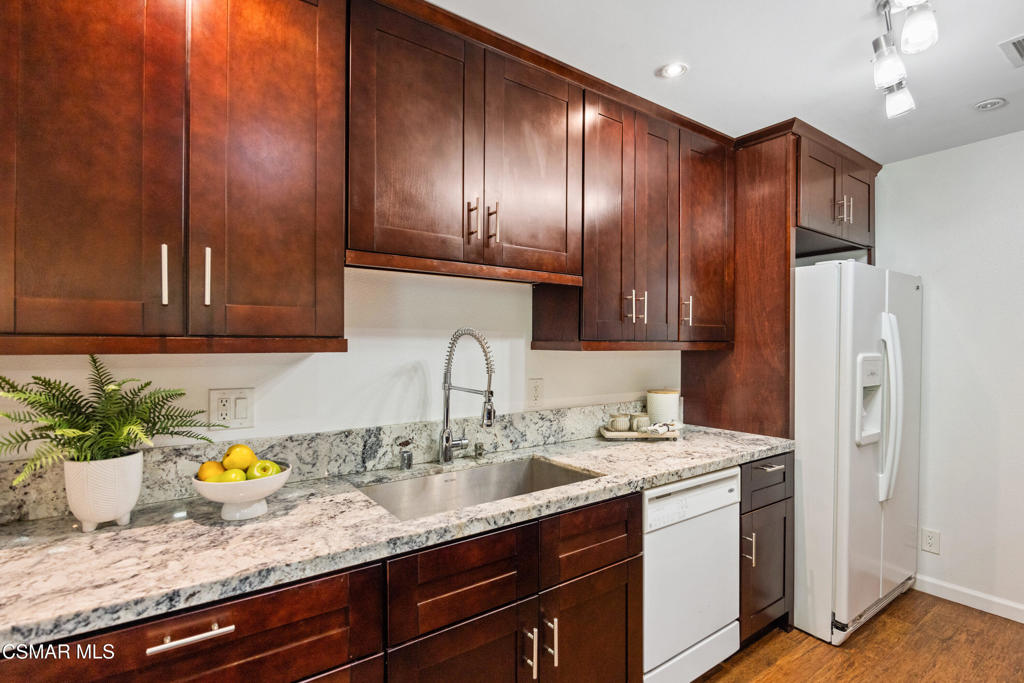 23637 Park Capri, Unit 36 Calabasas, CA 91302 - Photo 22 of 39 a kitchen with stainless steel appliances granite countertop a sink a stove cabinets and wooden floor