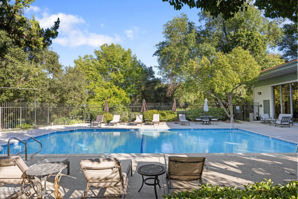 23637 Park Capri, Unit 36 Calabasas, CA 91302 - Photo 36 of 39 a view of a patio with table and chairs and potted plants with wooden floor and fence