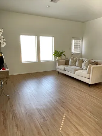 a living room with furniture and a hard wood floor