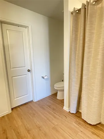 a big room with wooden floor and a bathroom