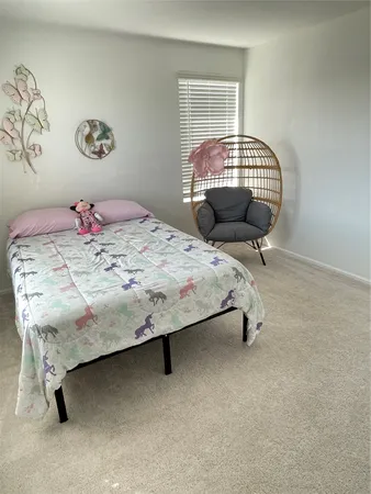a bed sitting in a bedroom next to a window