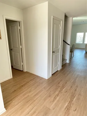 an empty room with wooden floor and mirror