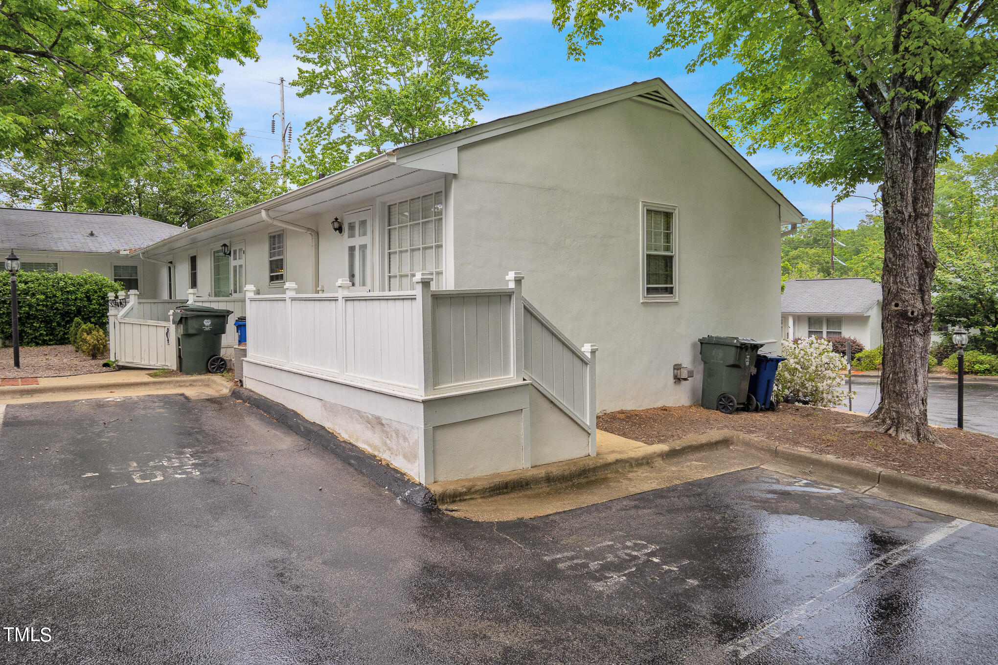 1941 Clark Avenue, Unit 101 Raleigh, NC 27605 - Photo 4 of 15 a view of a white house with a large tree and wooden fence