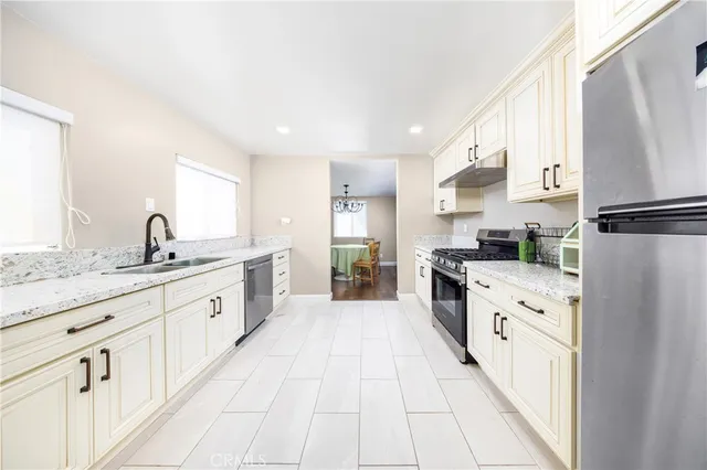 a large kitchen with granite countertop a sink and white appliances