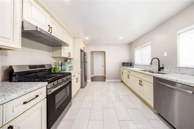 a large kitchen with stainless steel appliances granite countertop a stove and a sink