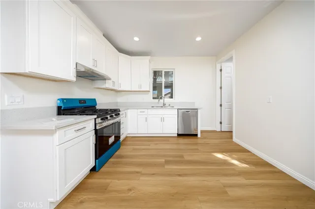 a kitchen with a sink stainless steel appliances and white cabinets