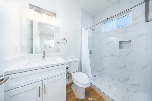 a bathroom with a sink a toilet and shower