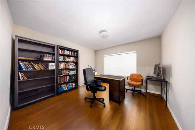 a view of a workspace with furniture and a bookshelf
