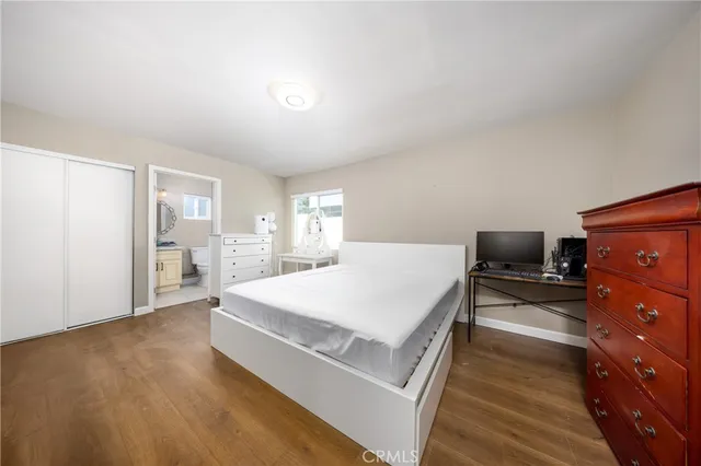 a spacious bedroom with a bed and wooden floor