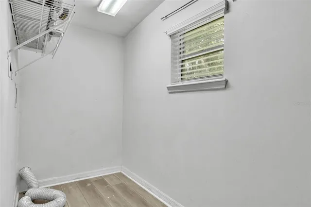a view of small space with wooden floor and a window